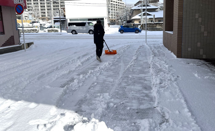 雪かきする社長